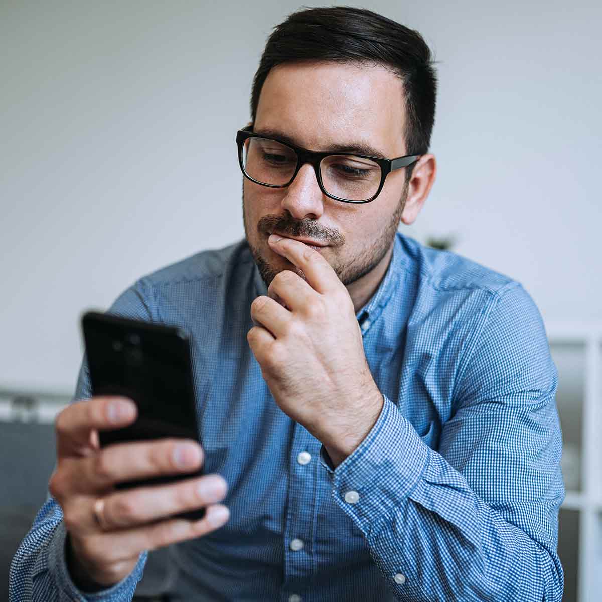 man-reading-phone-thinking