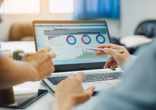 Advisor and client reviewing a financial plan summary on a laptop