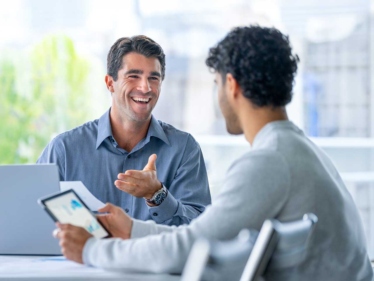A financial planner listening to client questions while working on a tablet
