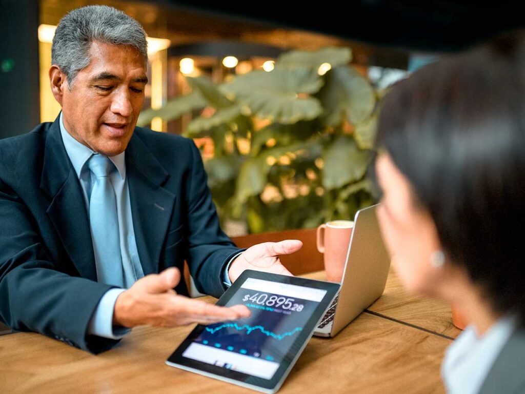 Client and advisor reviewing a financial plan on a tablet